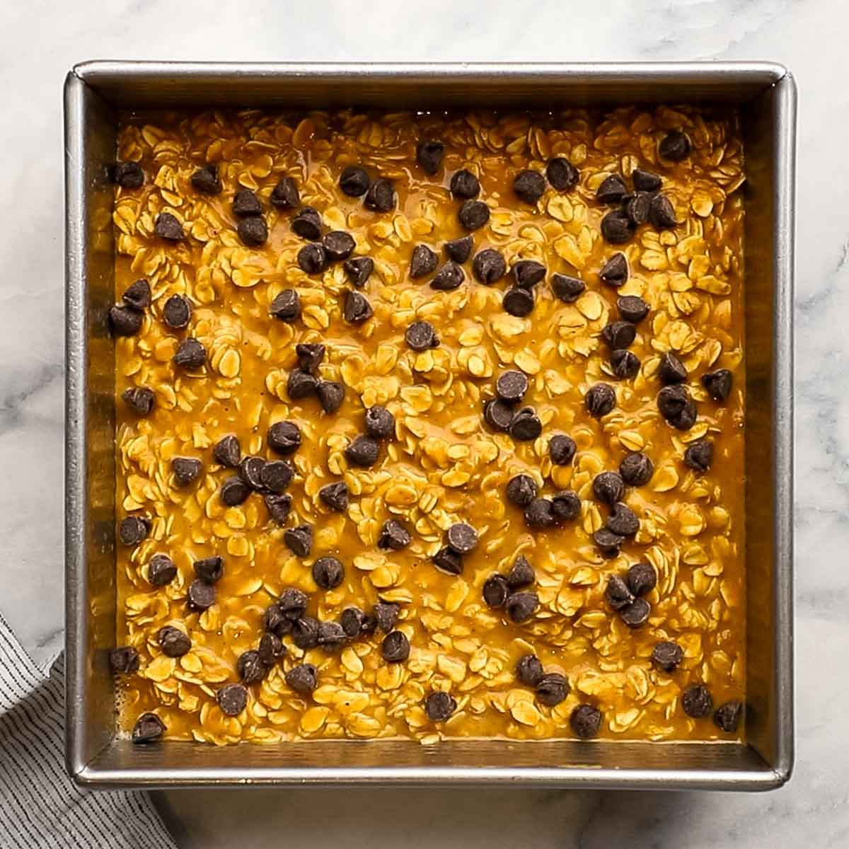 pumpkin oats mixture in a baking dish topped with chocolate chips