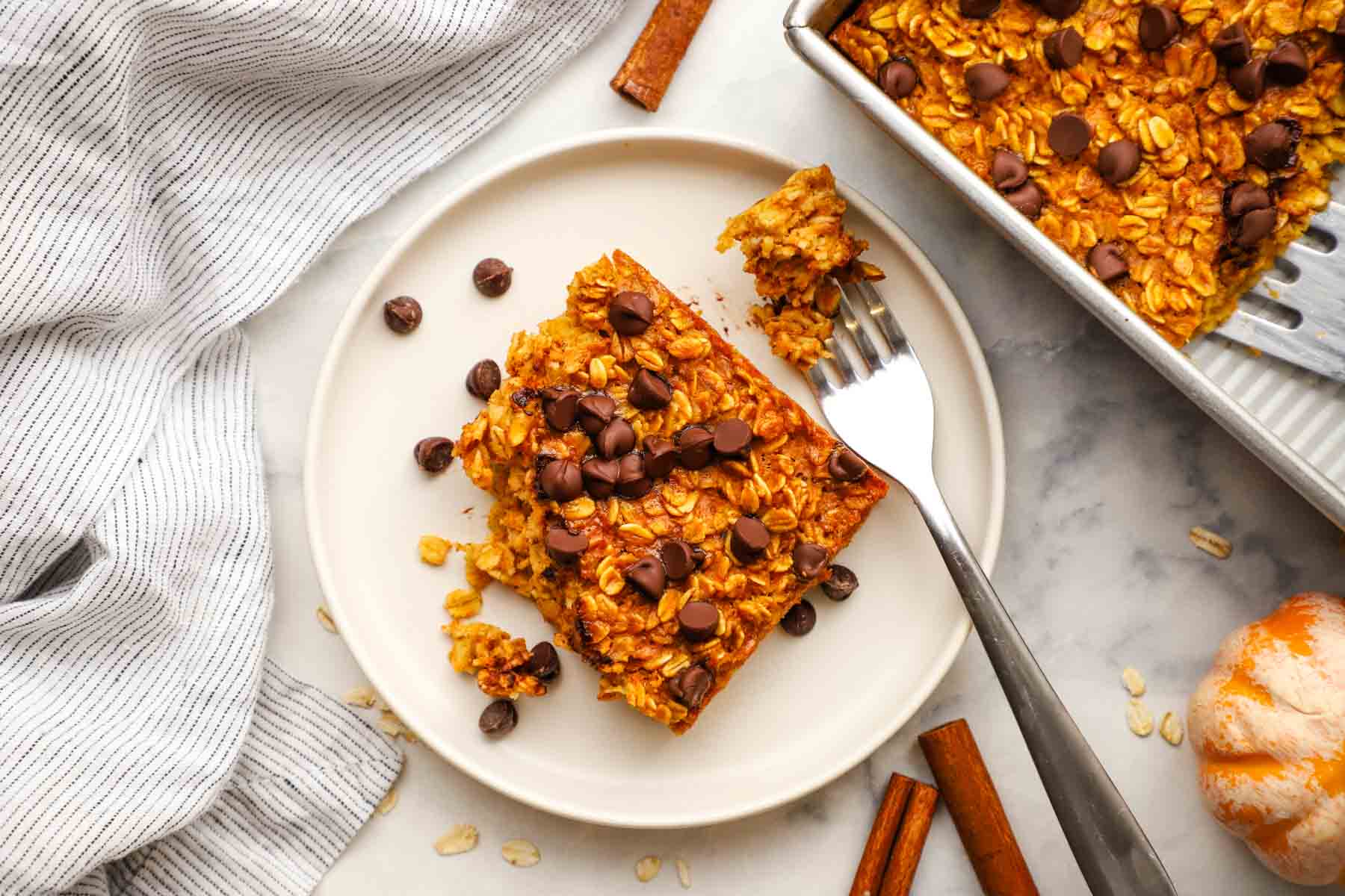 overhead view of a slice of pumpkin baked oatmeal with a bite taken out with a fork.
