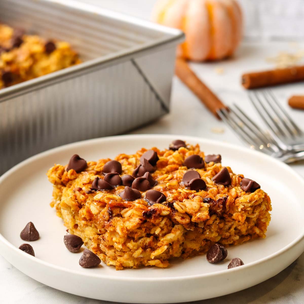 a slice of pumpkin baked oatmeal topped with chocolate chips on a plate.