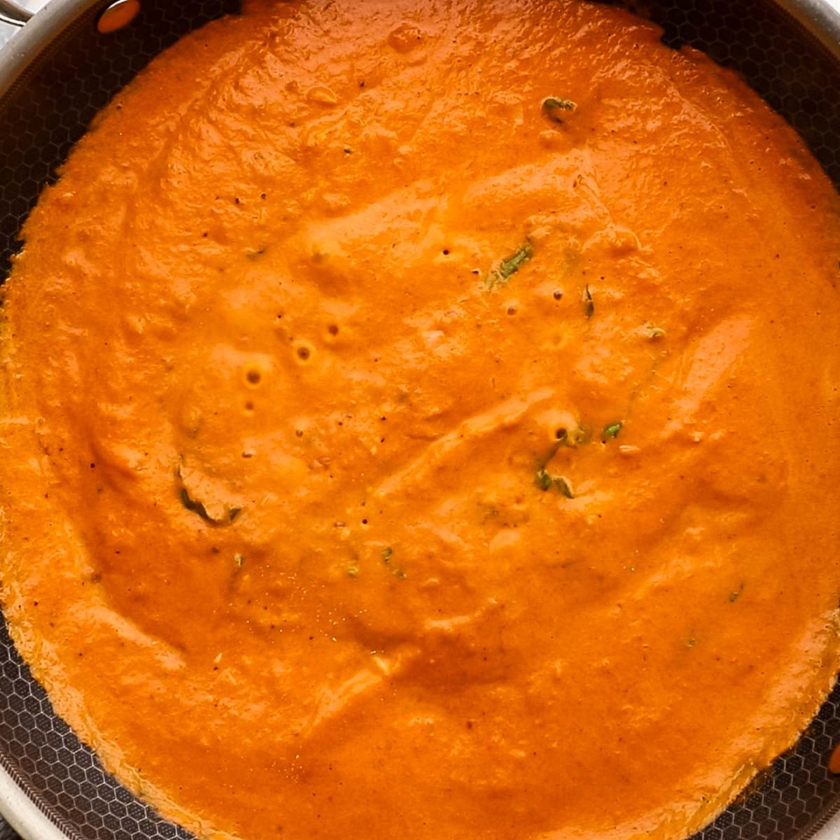 creamy roasted red pepper sauce simmering on the stove