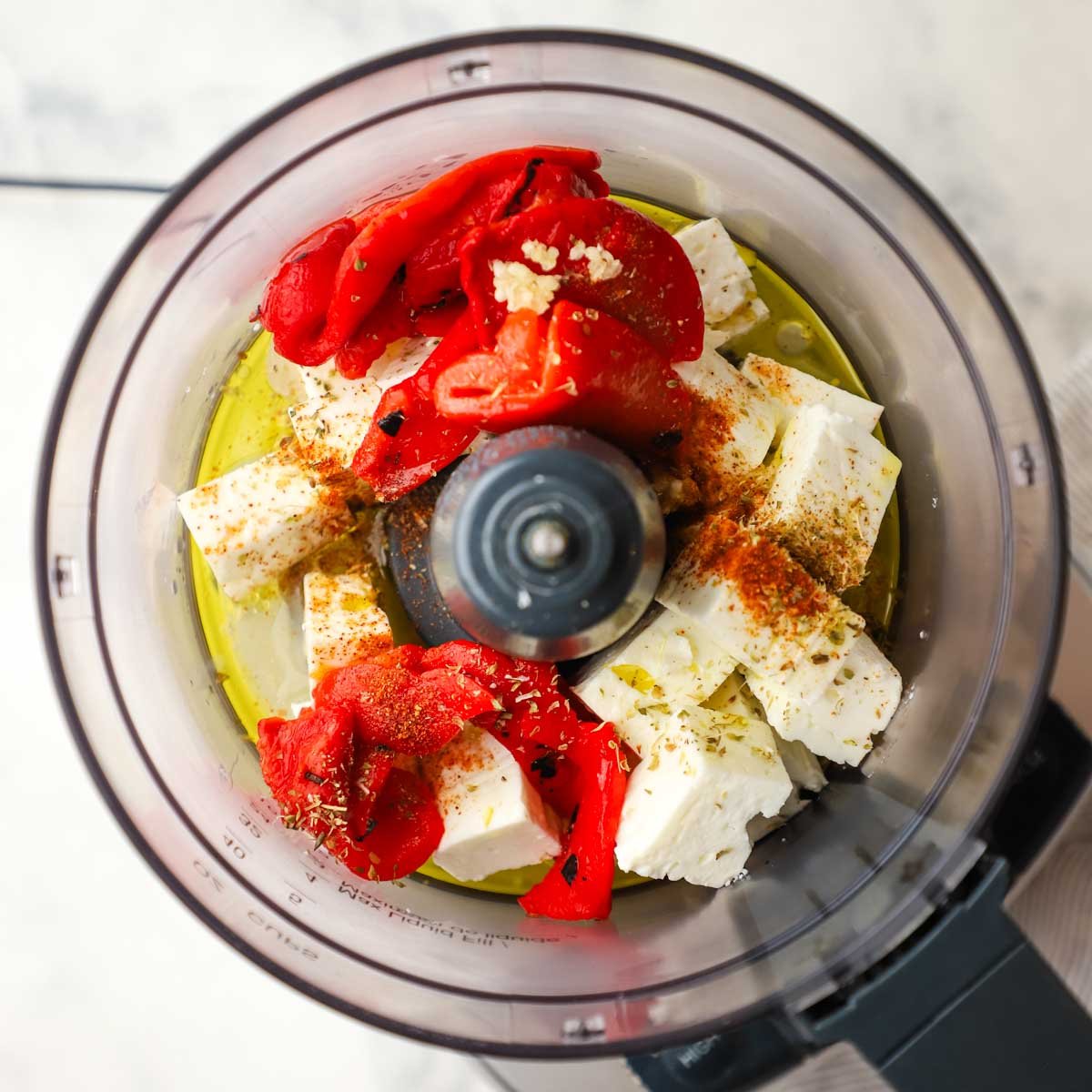 ingredients for feta and roasted red pepper dip in a food processor