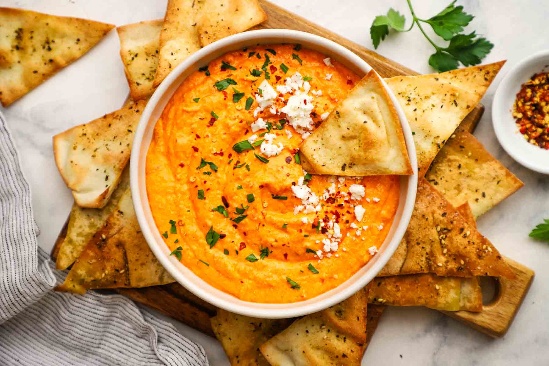 overhead view of a bowl of roasted red pepper and feta dip
