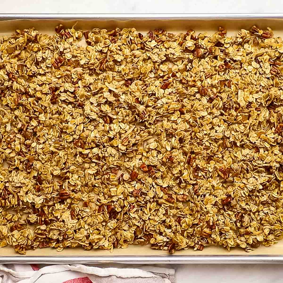 granola mixture spread on a baking sheet