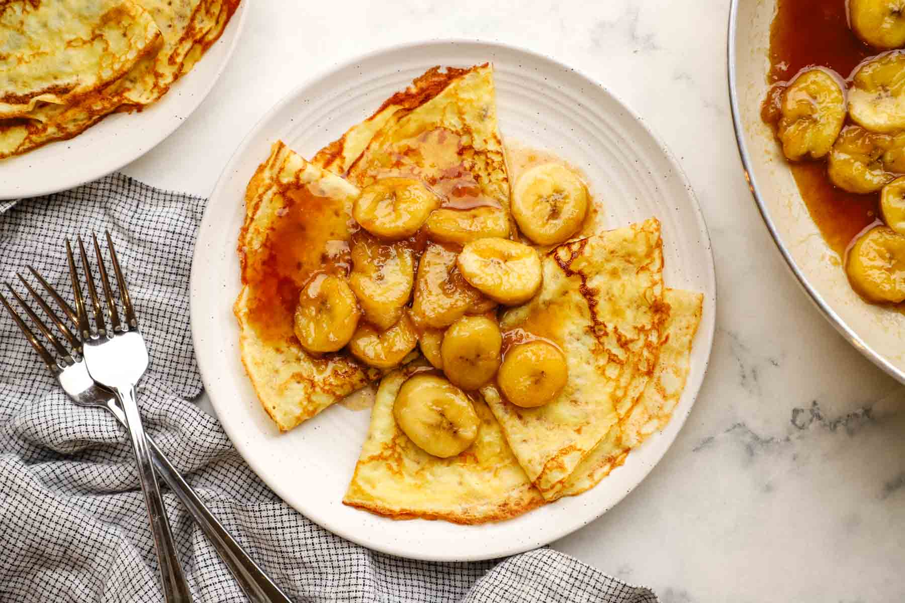 overhead view of a plate of banana foster crepes