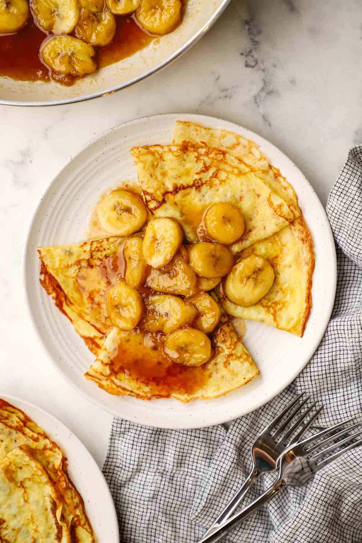 overhead view of a plate of banana foster crepes