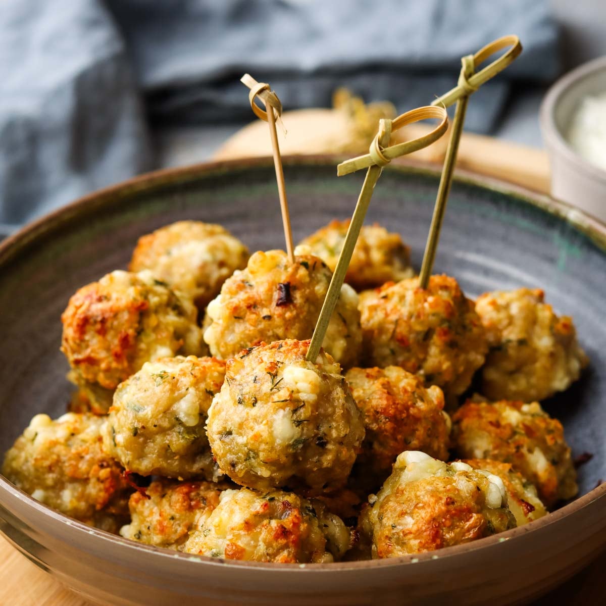 a bowl of chicken feta meatballs with toothpicks in it