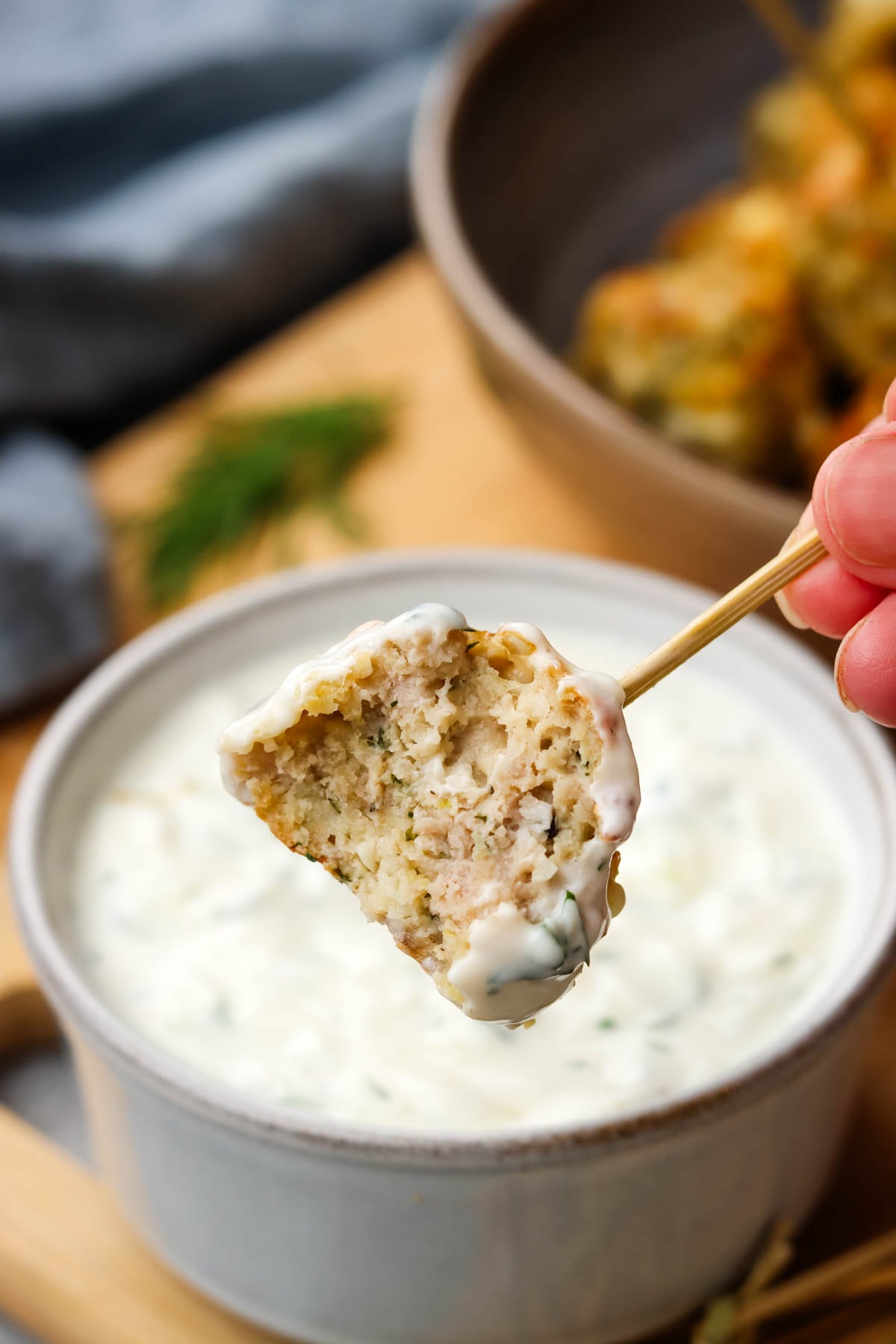 a half bitten chicken feta meatball on a toothpick