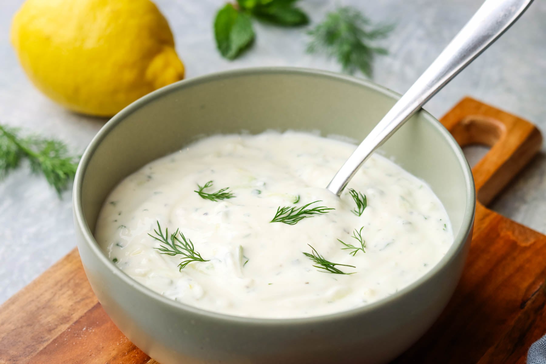 a bowl of cucumber yogurt dip with a spoon in it