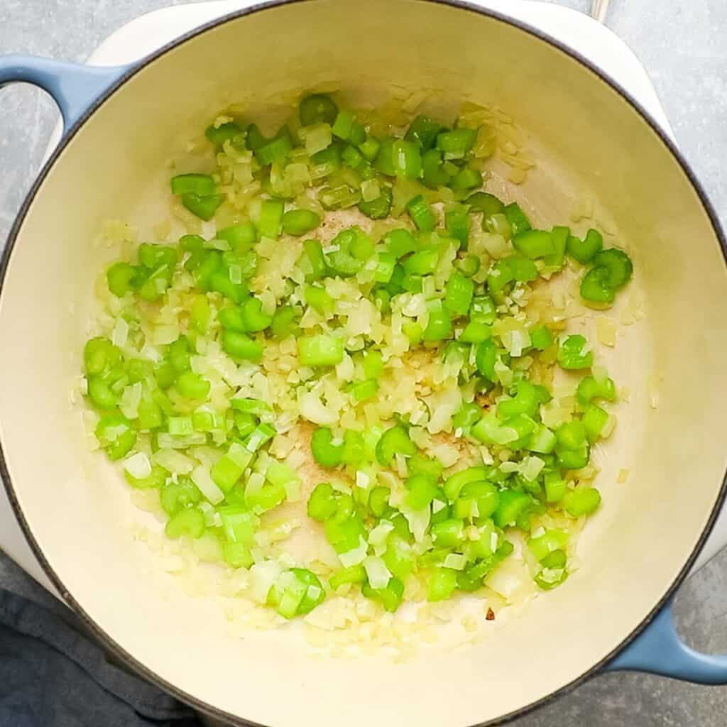 Vegetables being sauteed in a pot for the base of a soup.