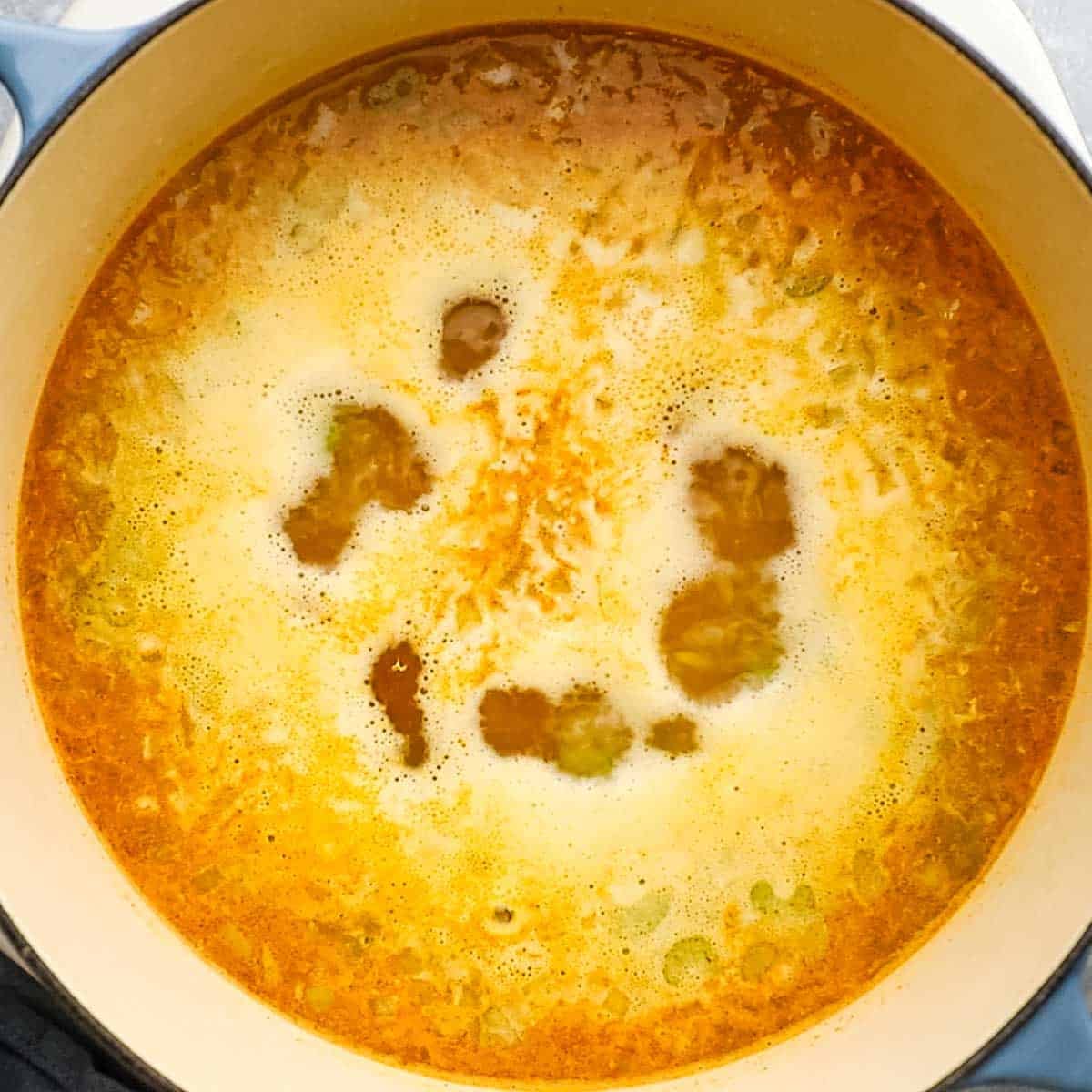 Soup in a pot being brought to a boil.