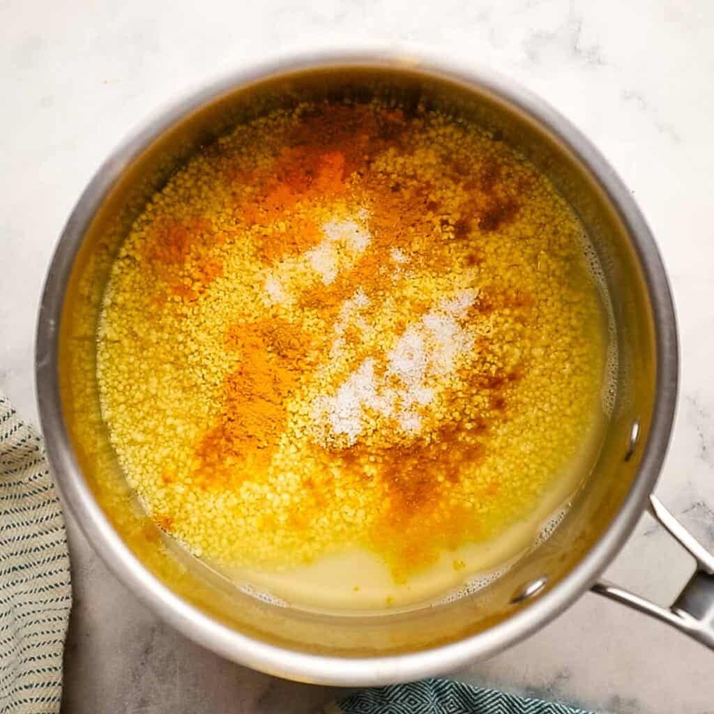 A pot of uncooked couscous with flavorings.