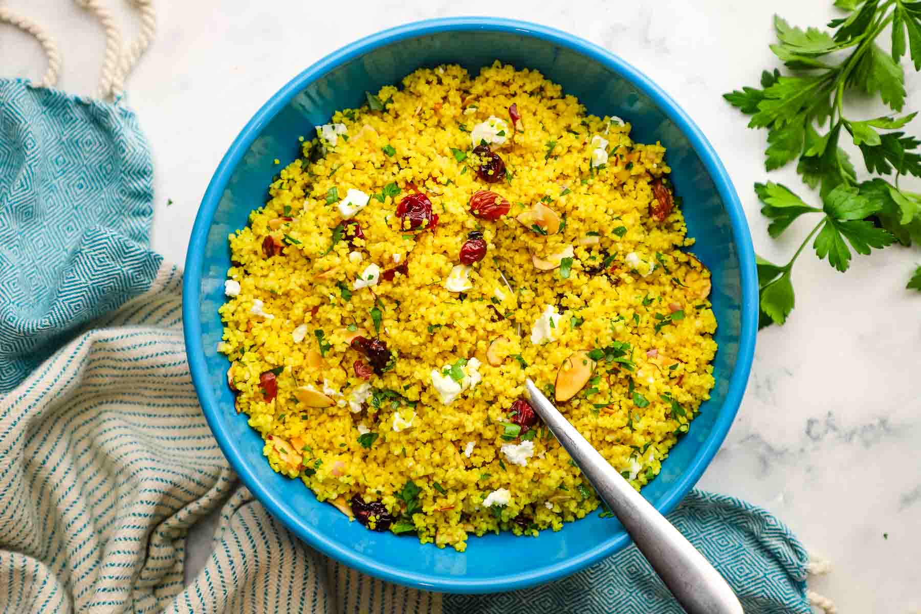 A serving bowl of curried couscous salad.