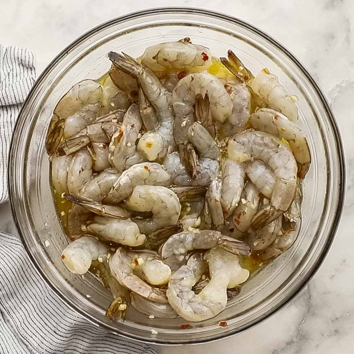 shrimp added to the marinade in a big bowl.