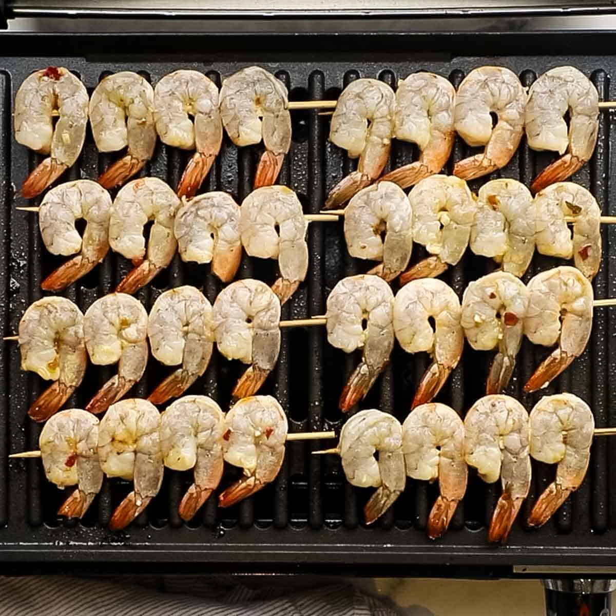 shrimp skewers placed on a grill pan