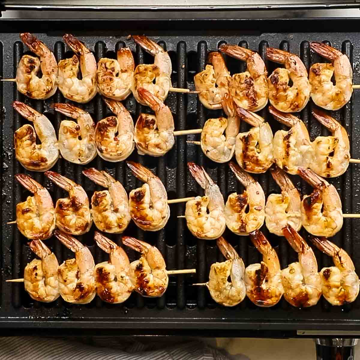 cooked shrimp skewers on a grill pan