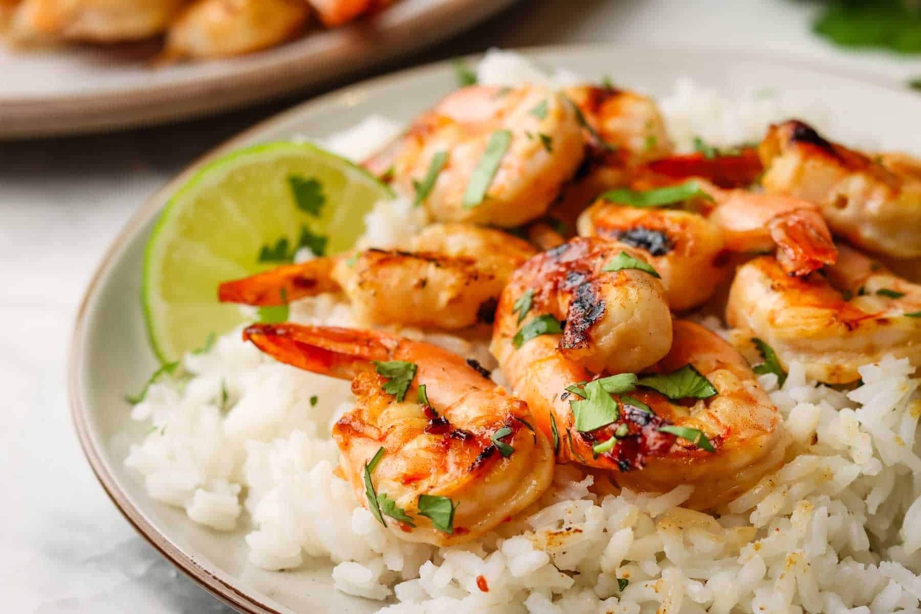 shrimp skewers served over a bed of rice on a plate