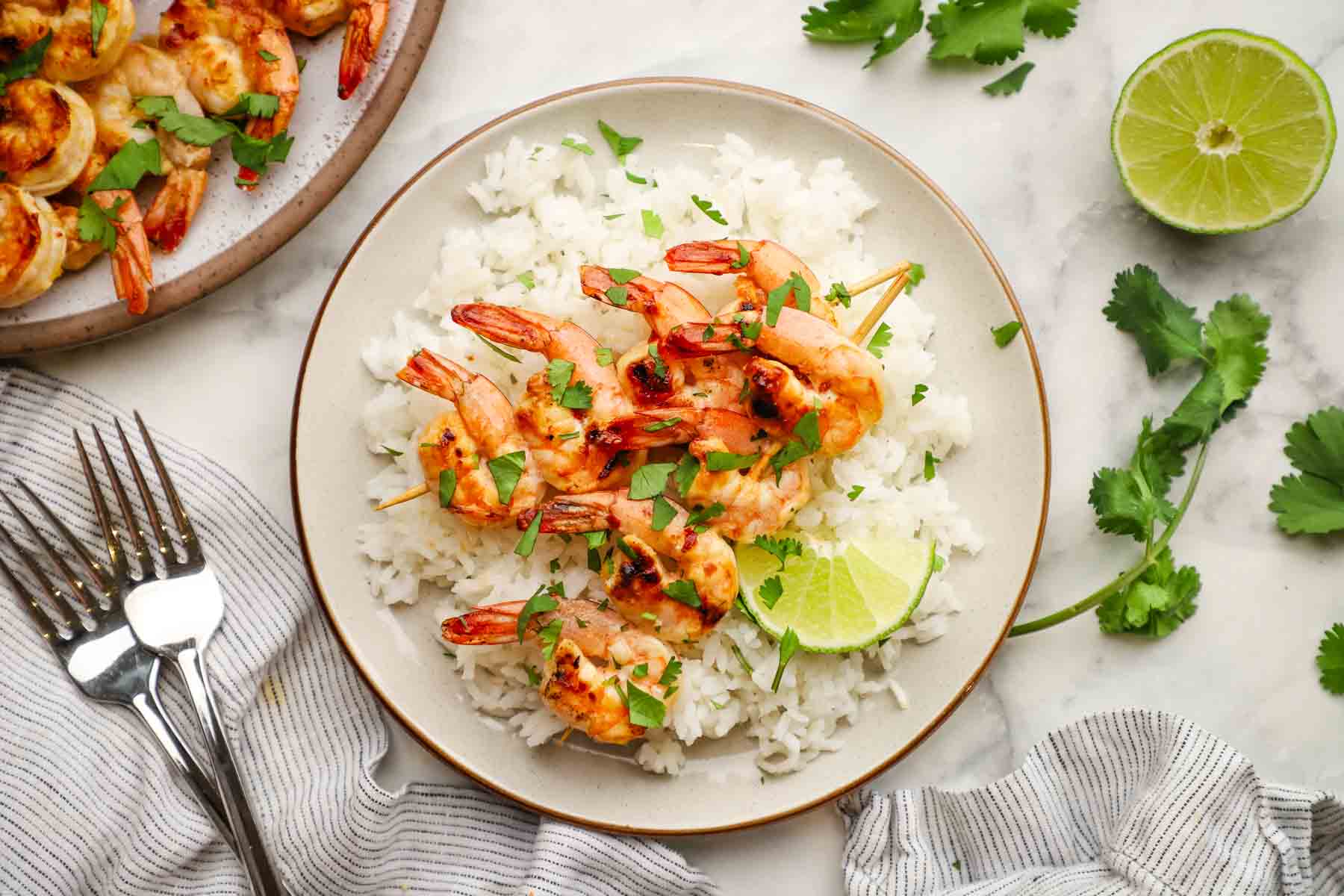 chili lime shrimp served over rice in a plate.