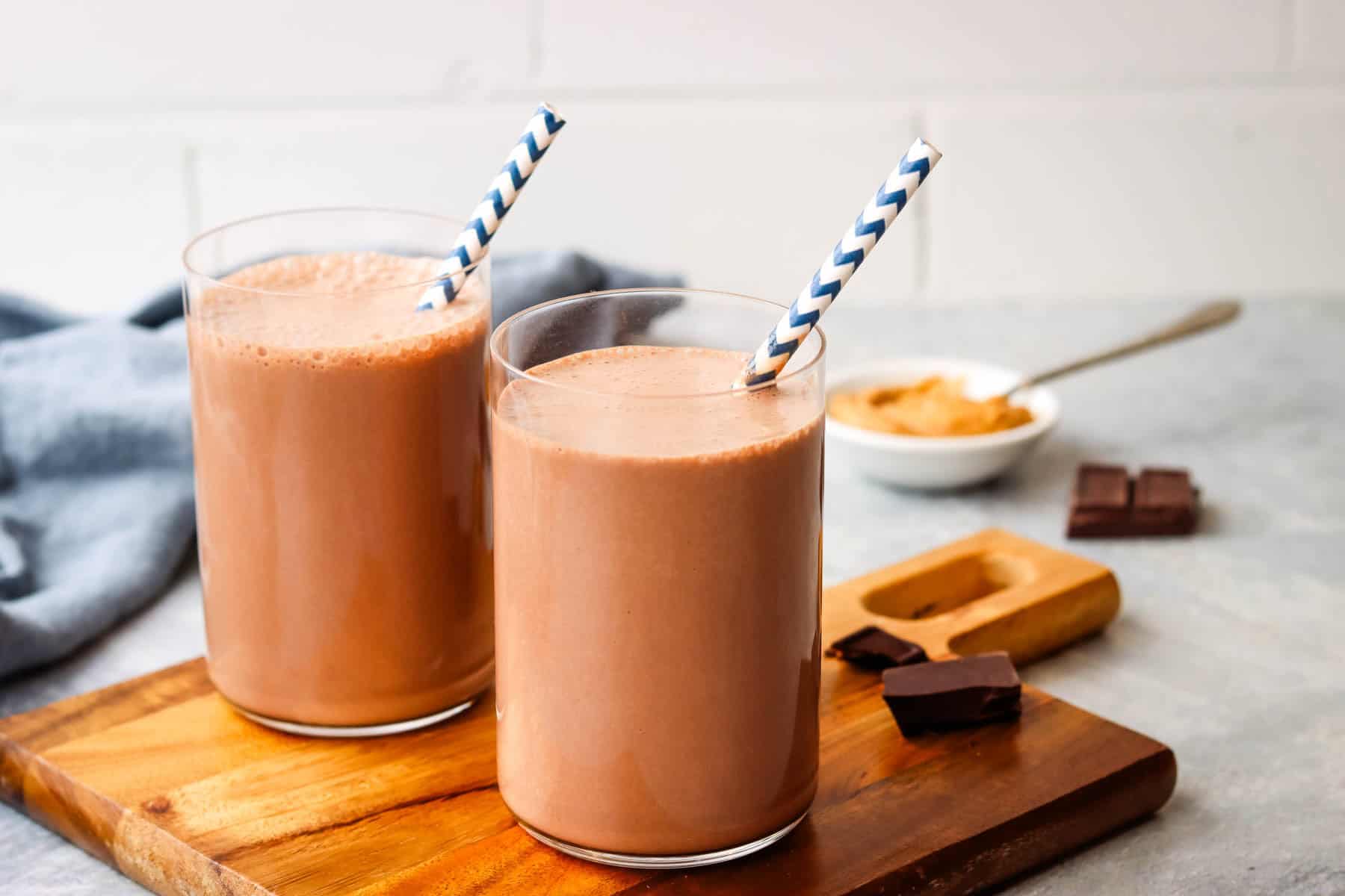 Two smoothies on a wooden board.
