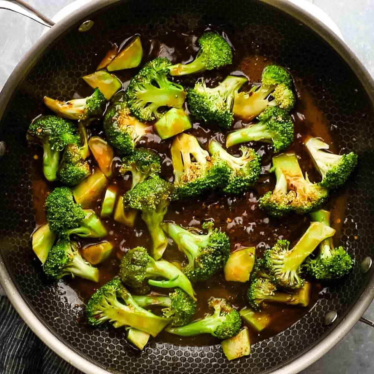 Top-down view of broccoli now being sautéed with the stir fry sauce for broccoli and pork stir-fry. 