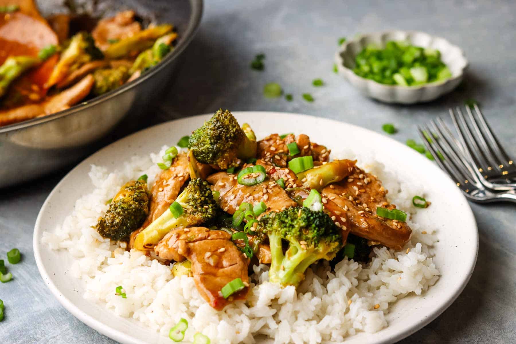 Side view of Broccoli and Pork, on top of white rice to make stir-fry, and ready to be served.