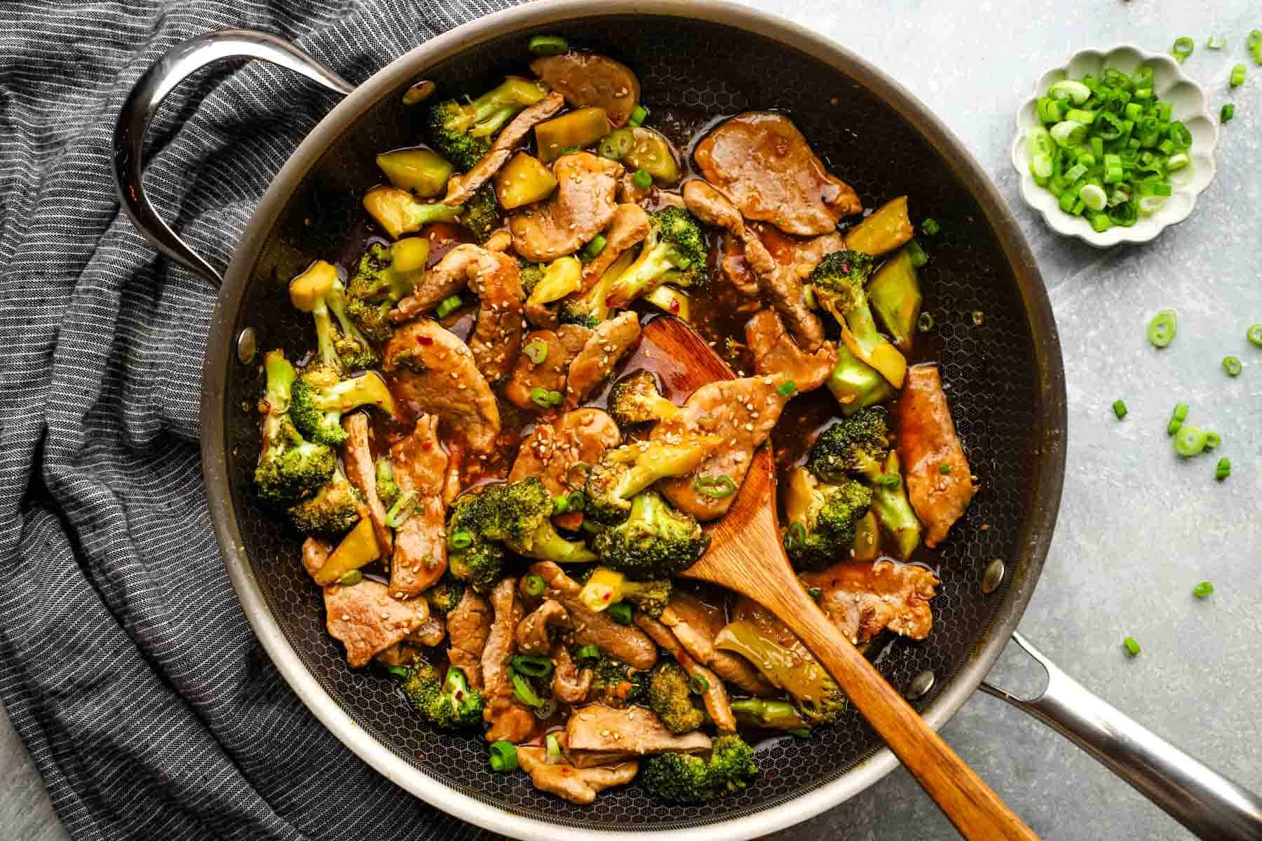 A pan of pork and broccoli stir fry.