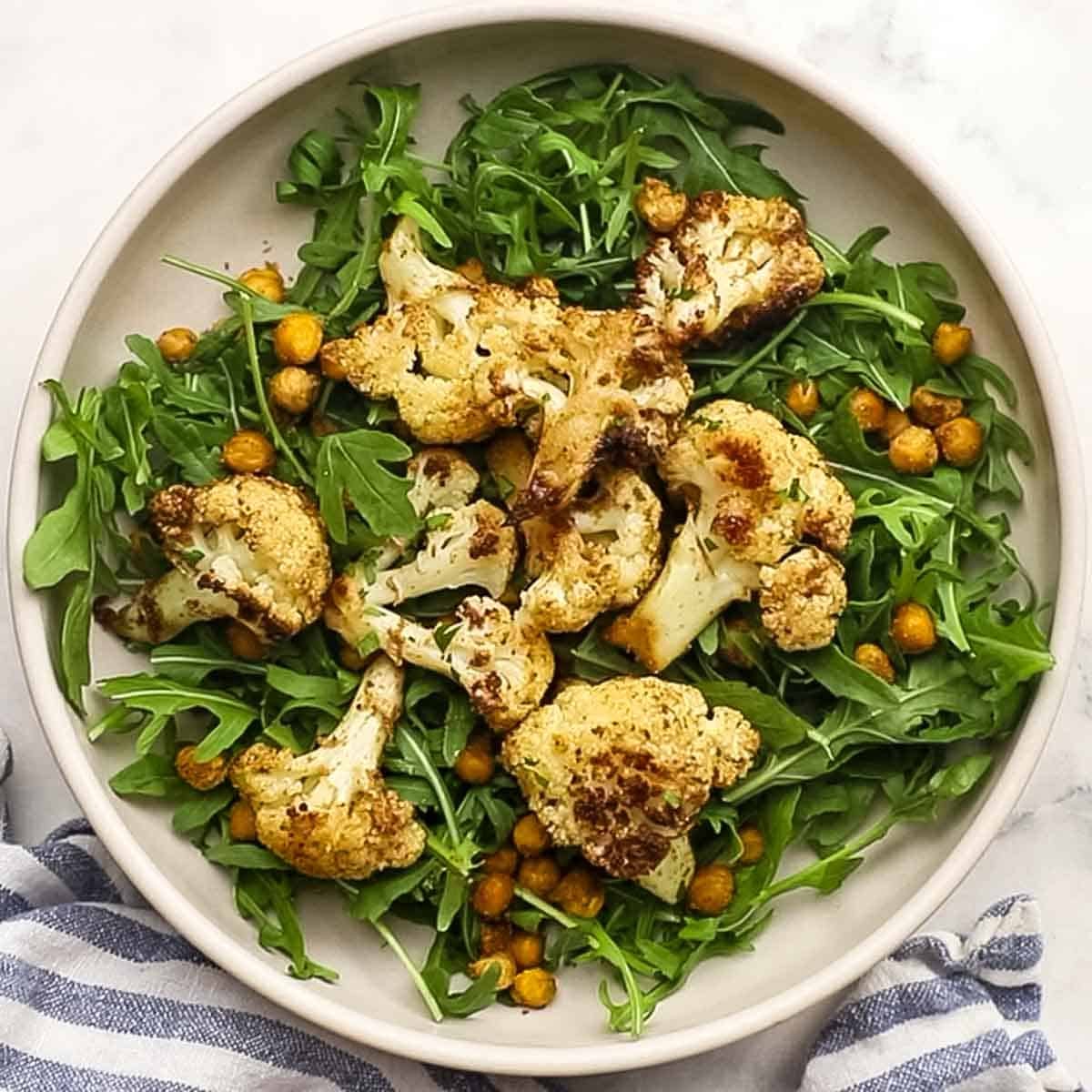 fresh arugula topped with roasted cauliflower and chickpeas