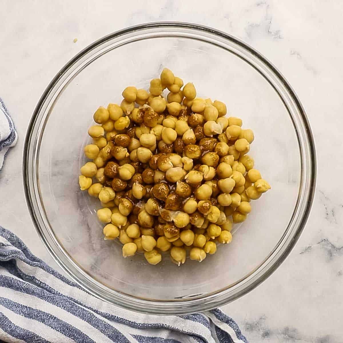 chickpeas tossed in a small bowl with the spice mixture
