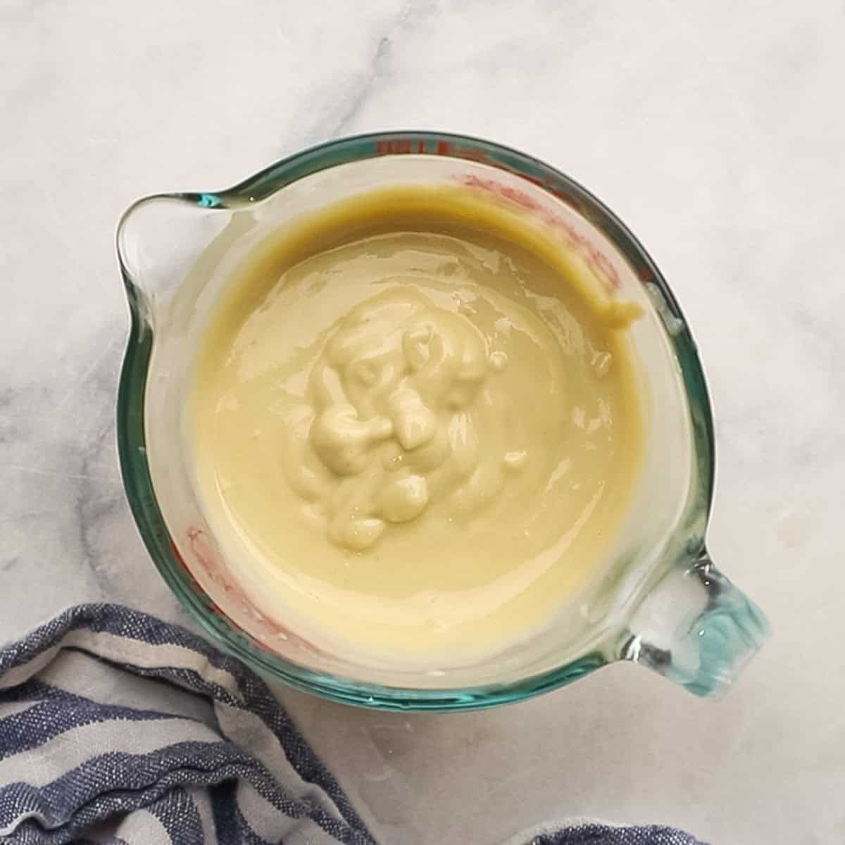 lemon tahini dressing in a measuring cup