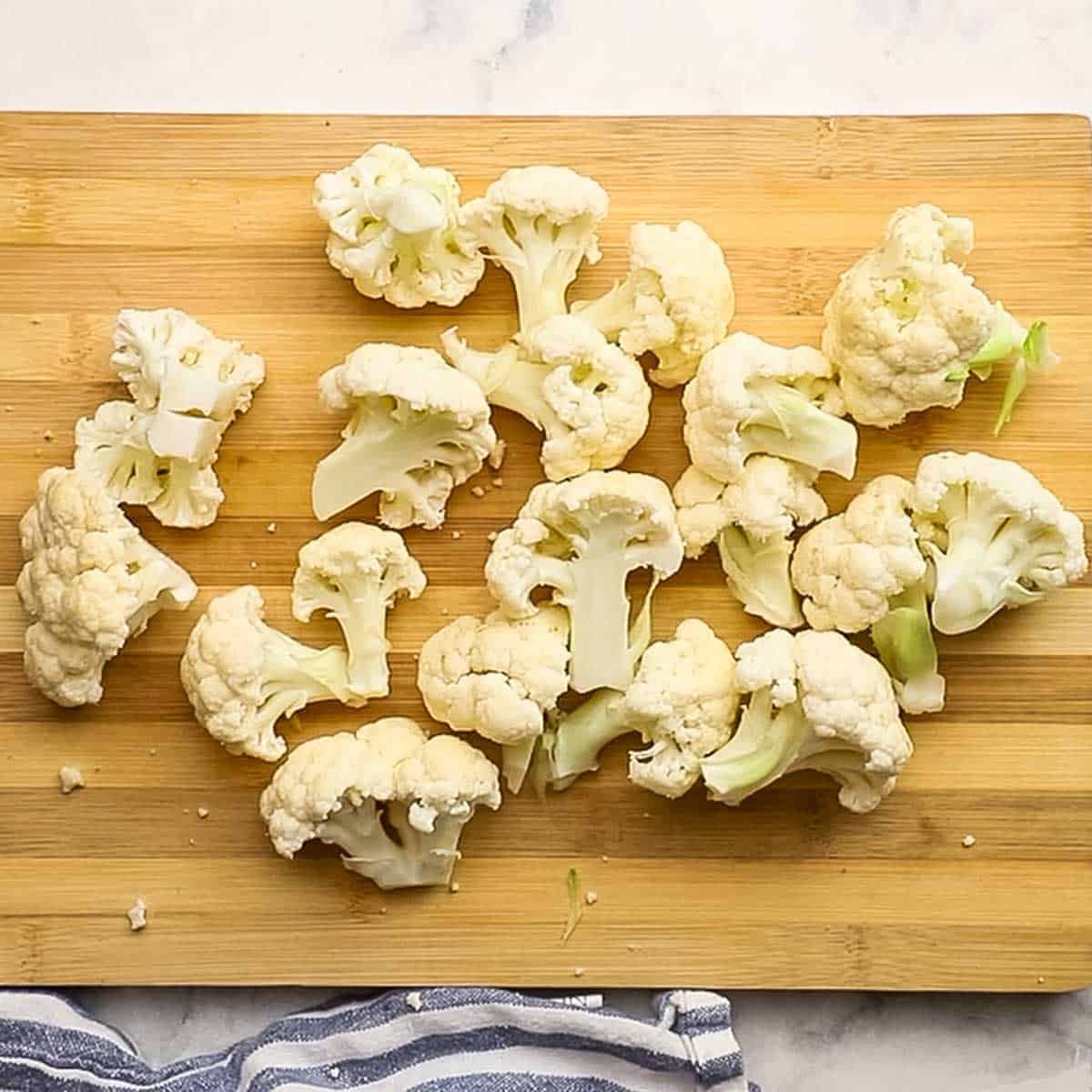 cauliflower florets spread on a cutting board