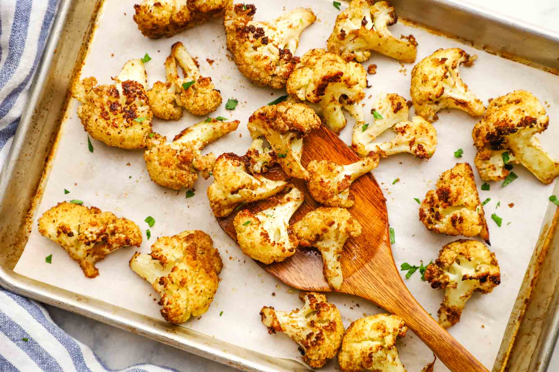 Roasted cauliflower florets on a baking sheet.