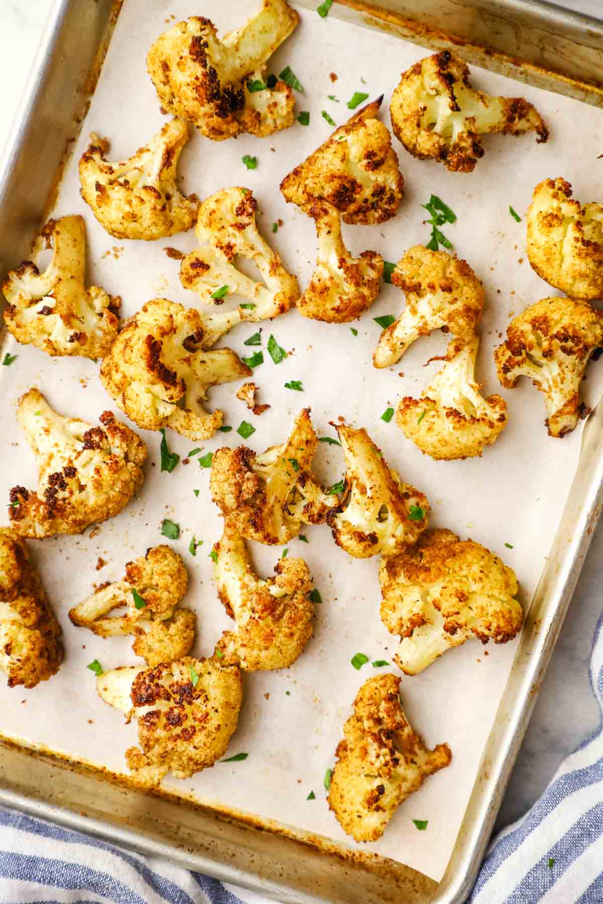 Roasted cauliflower florets on a baking sheet.