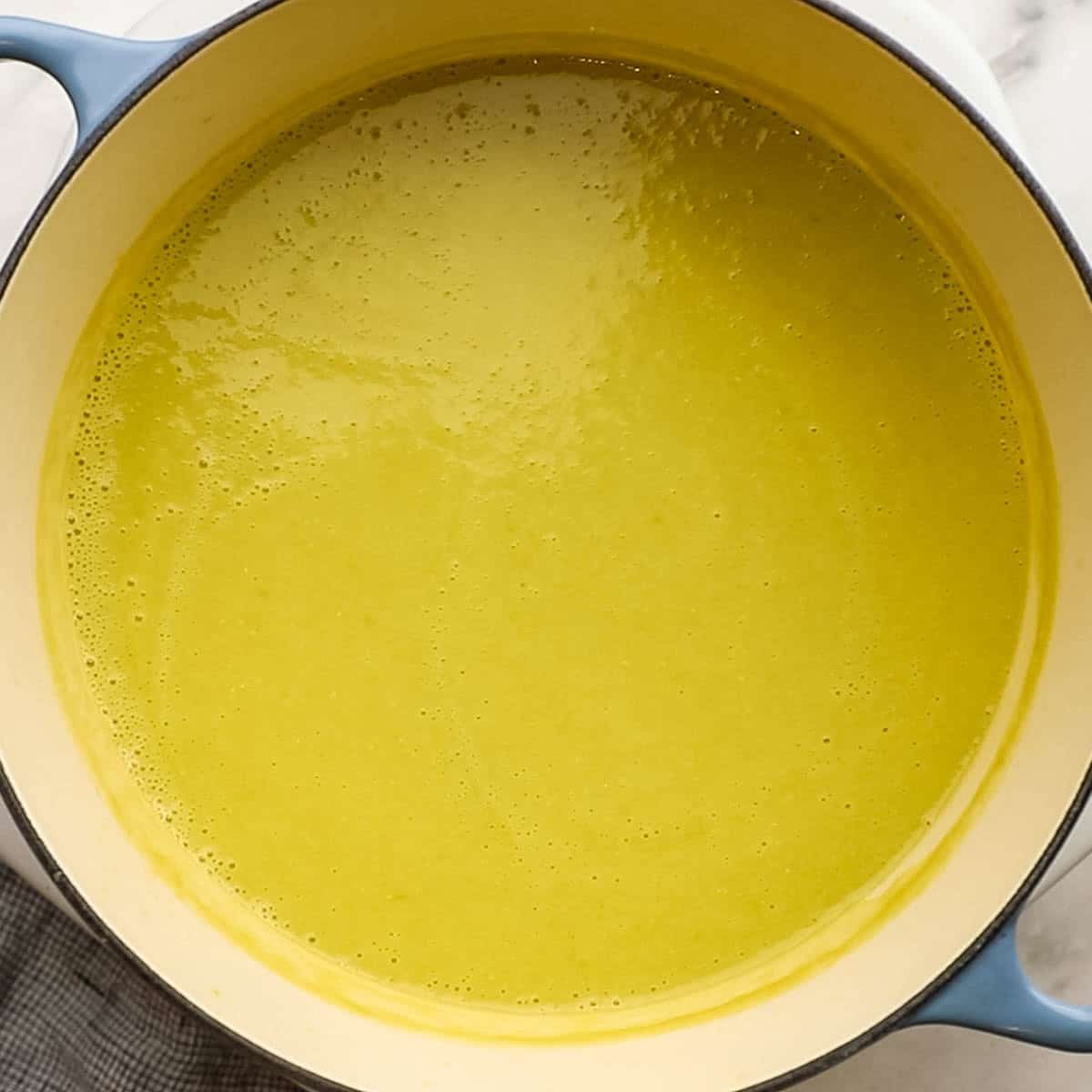 Simmering poblano soup mixture on low heat that have added lime and cream to it.