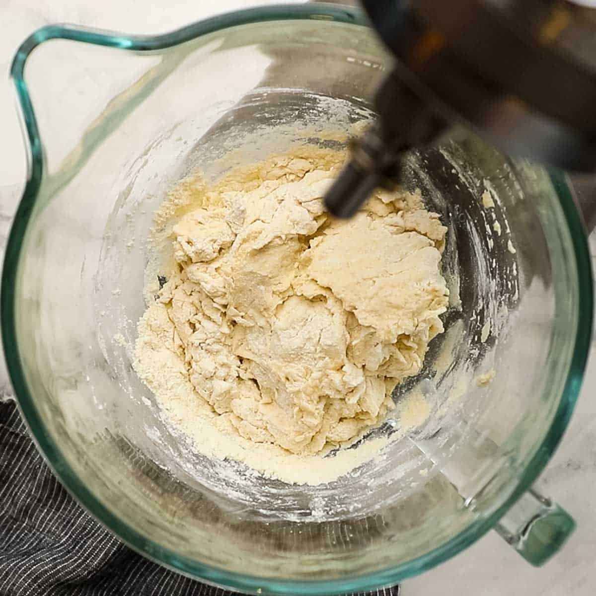 Top-down view of pizza dough after adding water to the flour, yeast, and salt and sugar mixture.