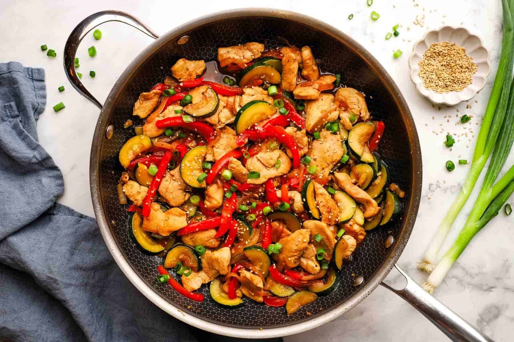A pan of chicken zucchini stir fry.