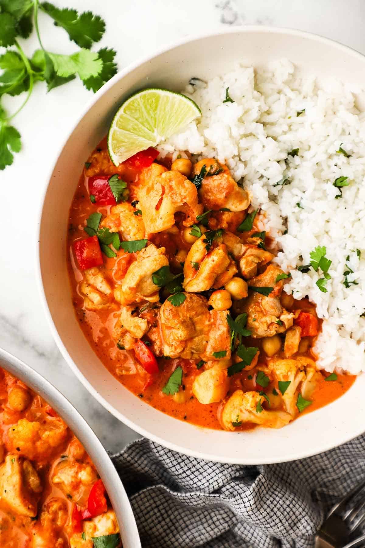 A bowl of chicken and chickpea curry served with rice.