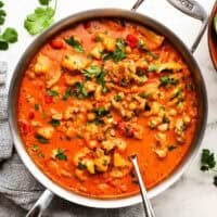 A pan of chicken and chickpea curry garnished with cilantro.