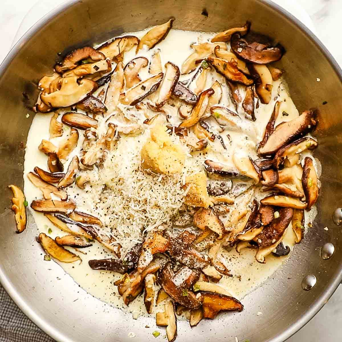 Heavy cream, parmesan, miso, lemon juice, and black pepper added to the shiitake garlic and scallions cooking in the skillet.