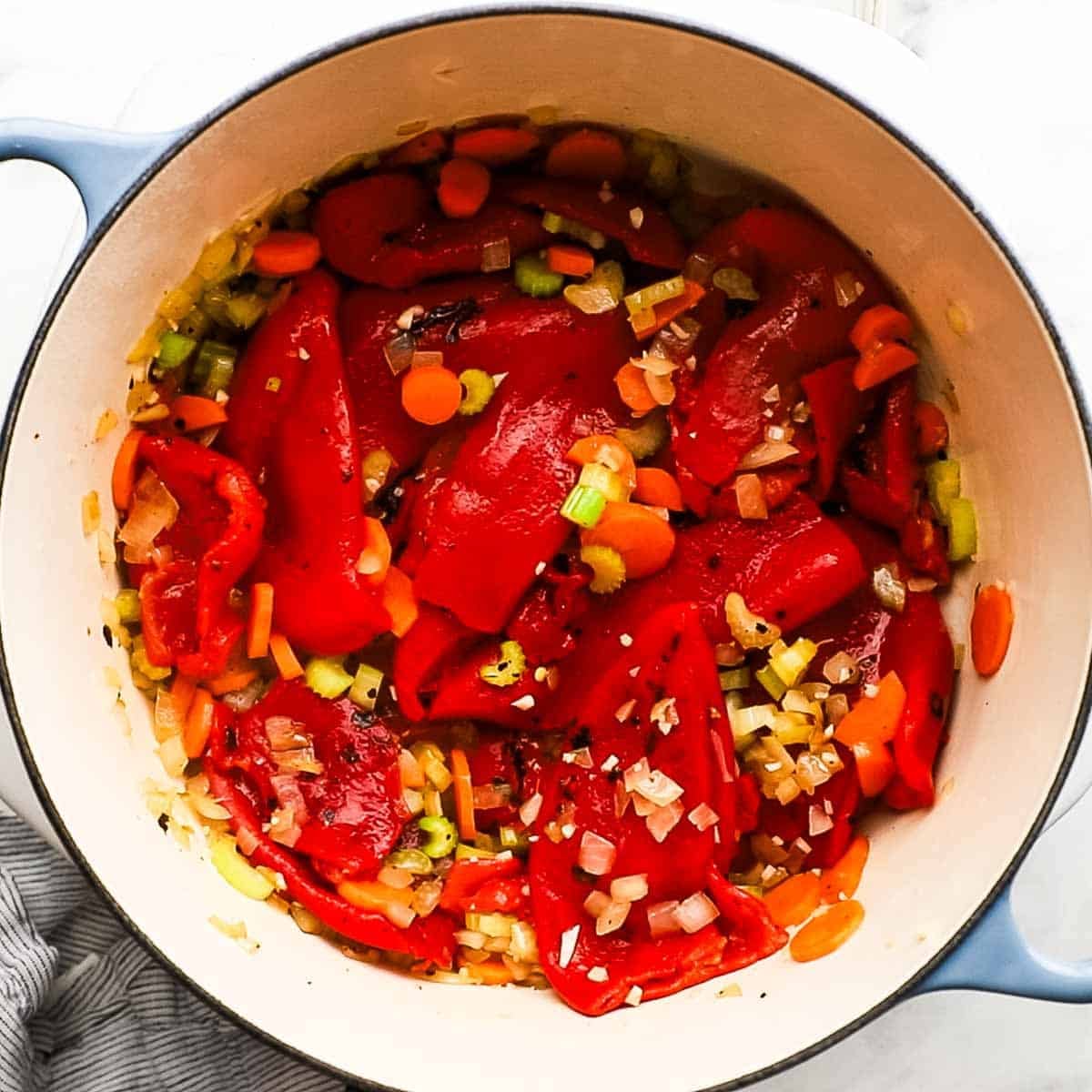 Roasted red peppers added to the carrot, onion mixture in the dutch oven.