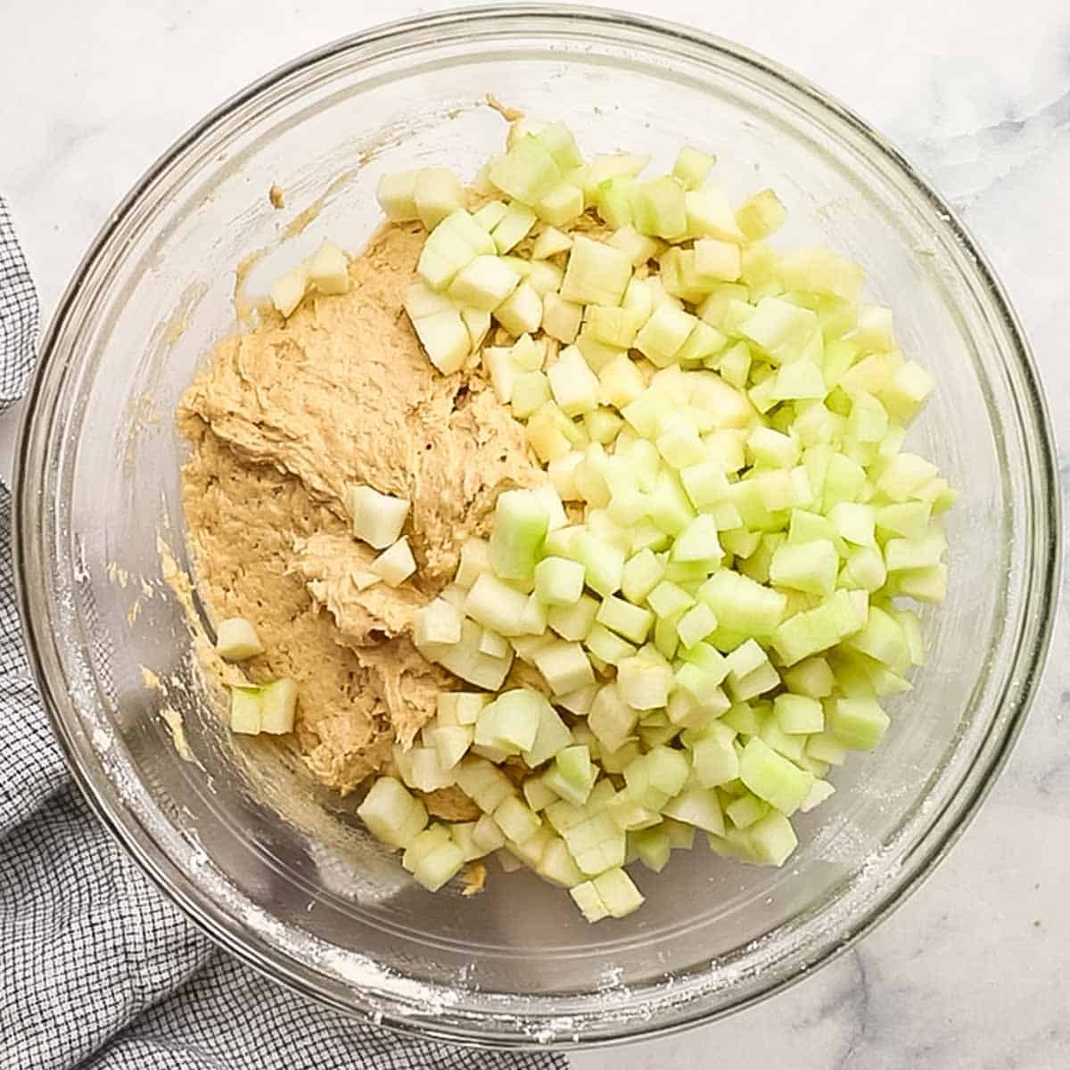 adding chopped apples to the muffin batter