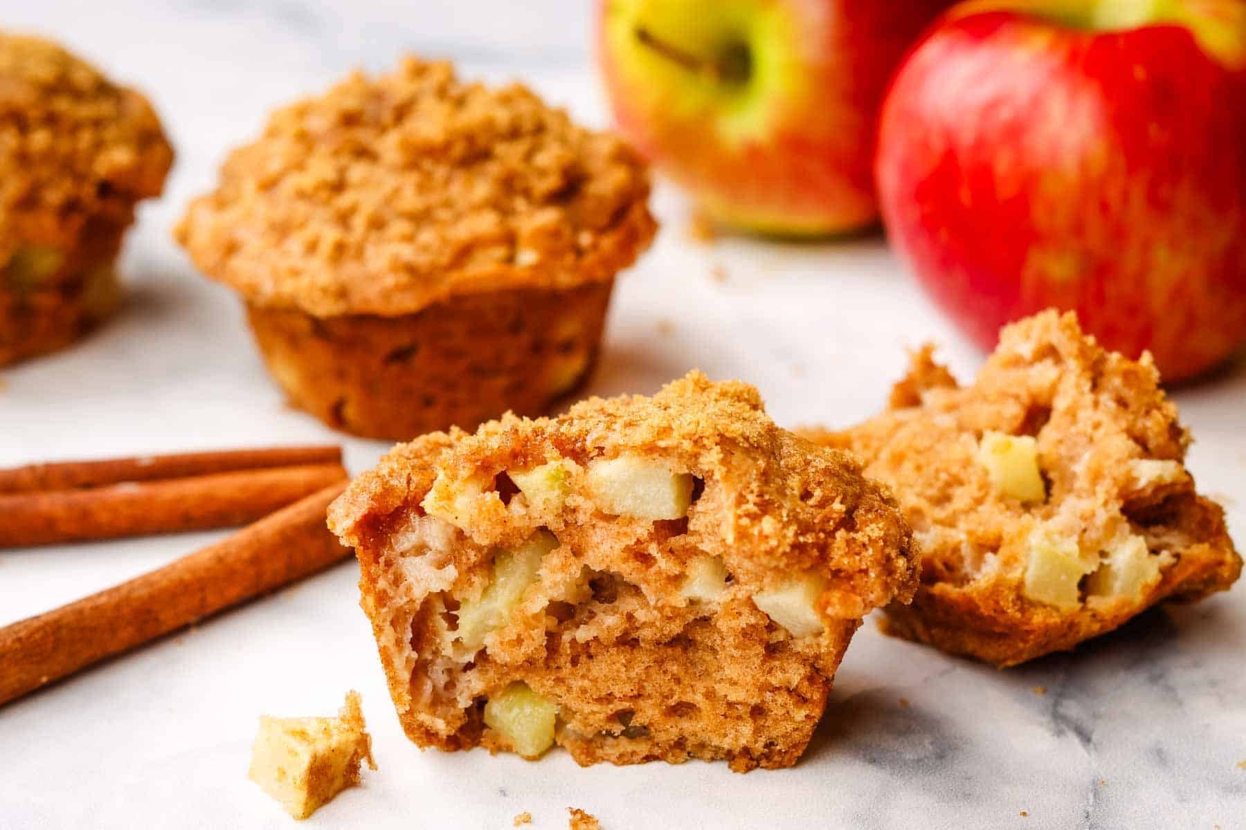 apple muffin on a plate cut in half to show the inside.