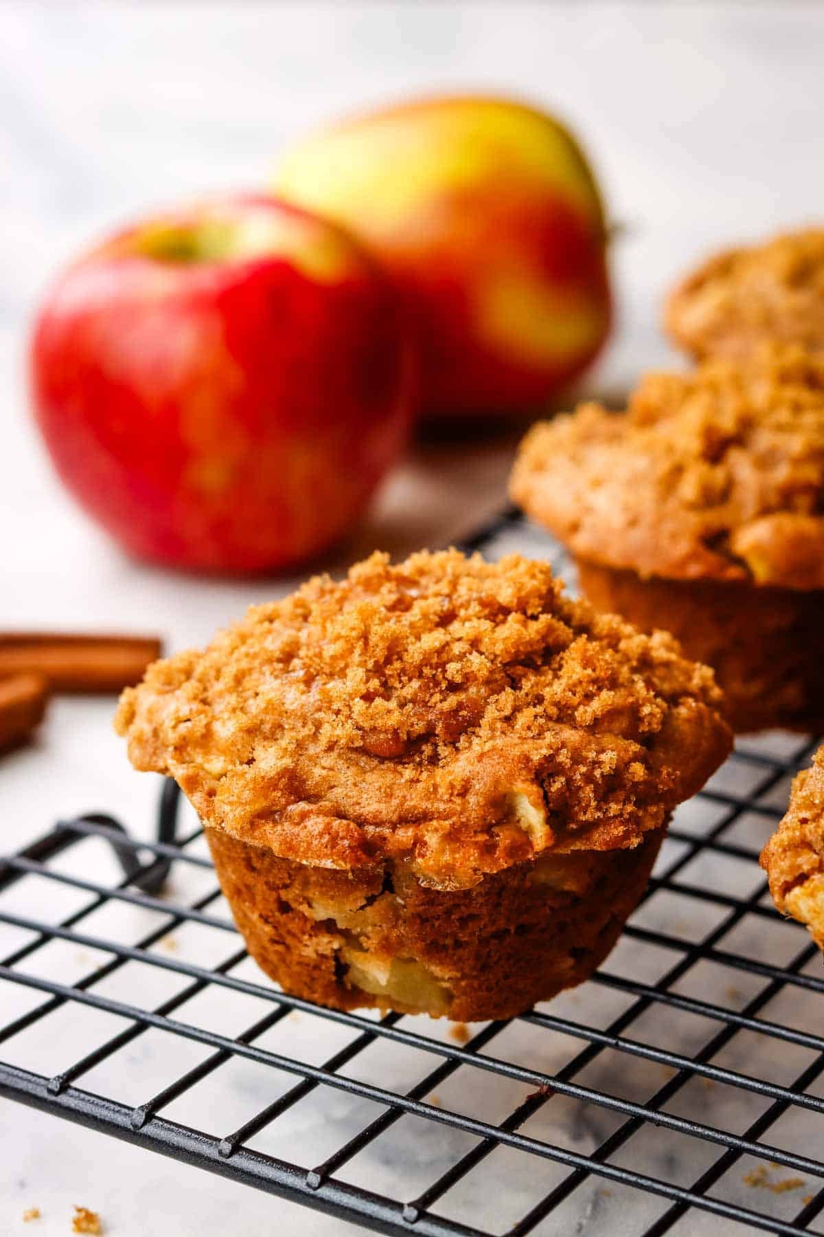 Apple sour cream muffins cooling on a wire rack.