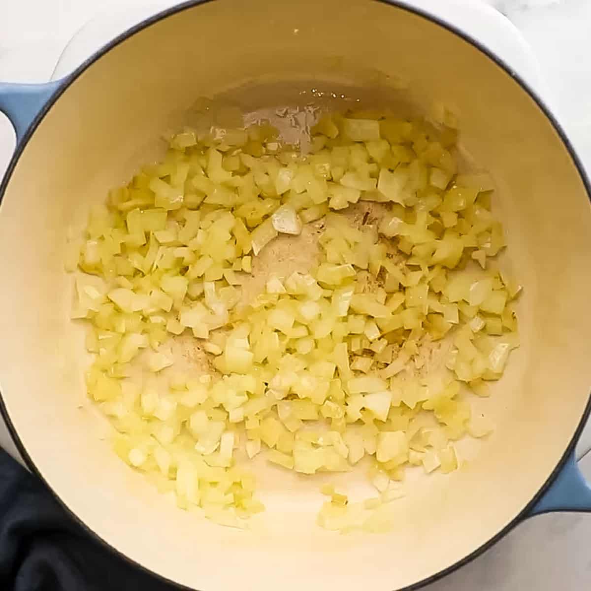Onions and garlic cooking in a large dutch oven for Baked orzo recipe.