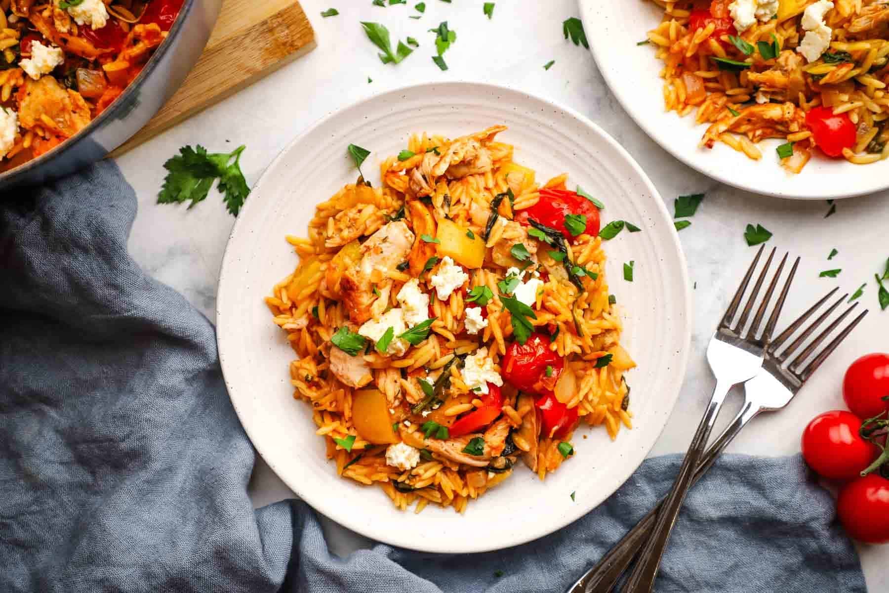 A plate of chicken and orzo topped with feta.