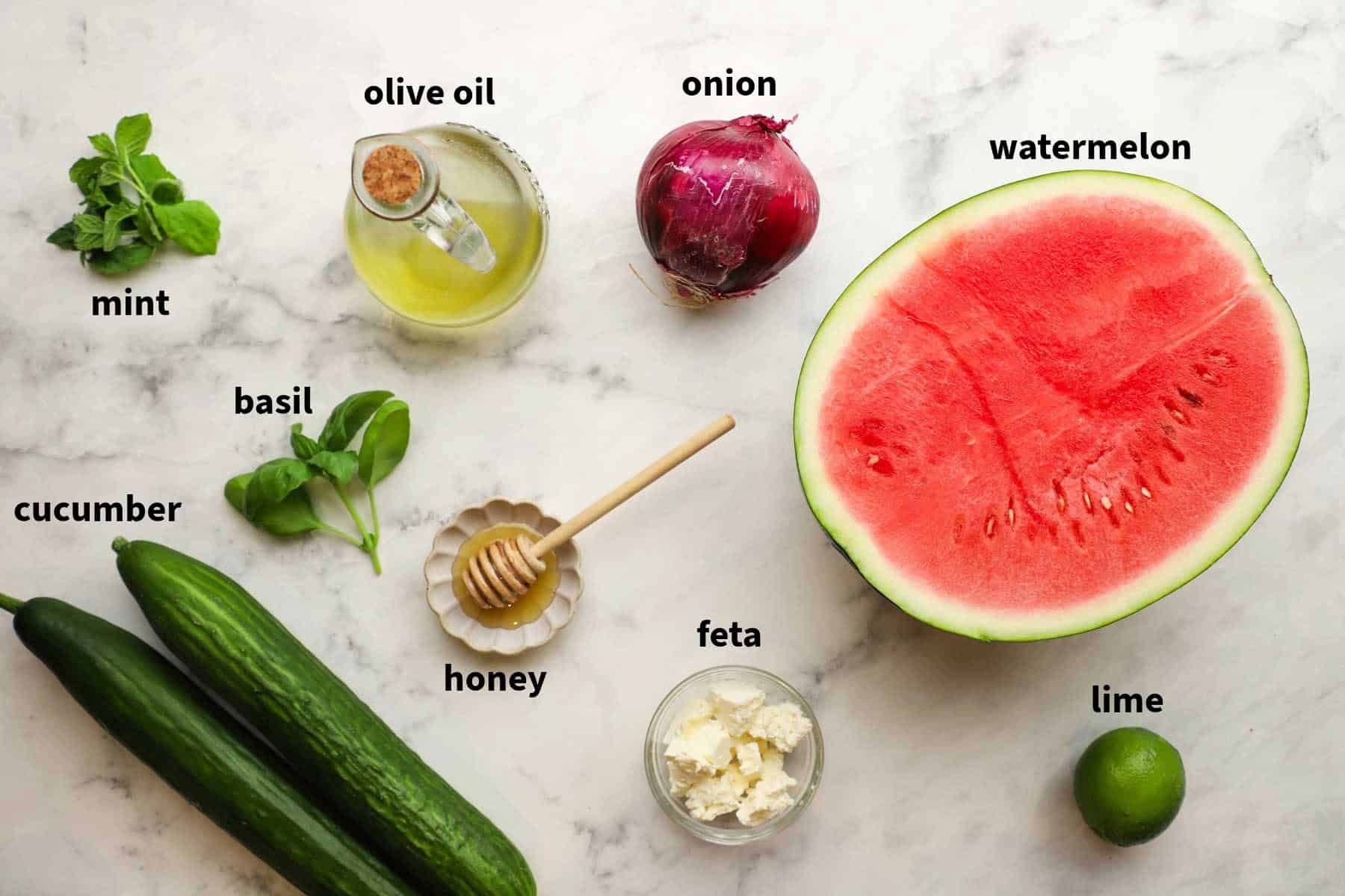 Ingredients for watermelon cucumber salad that include watermelon and cucumber, honey, mint, salt and pepper, feta, red onion, and more.