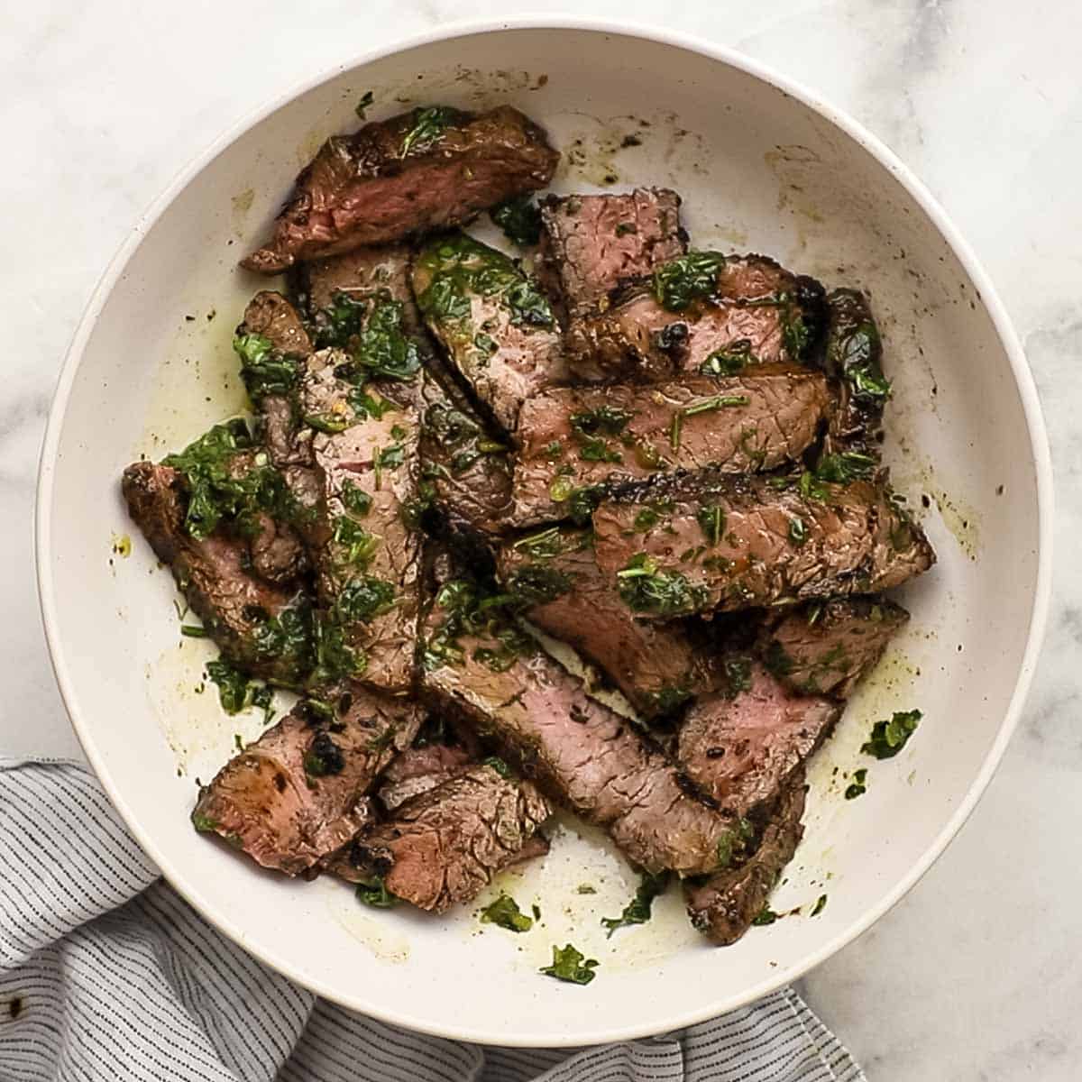 chimichurri mixed with steak in a bowl