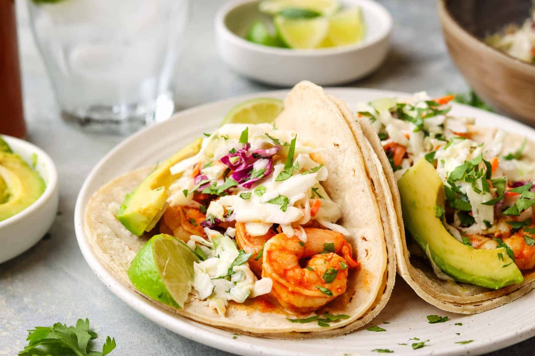 a shrimp taco on a plate with slaw.
