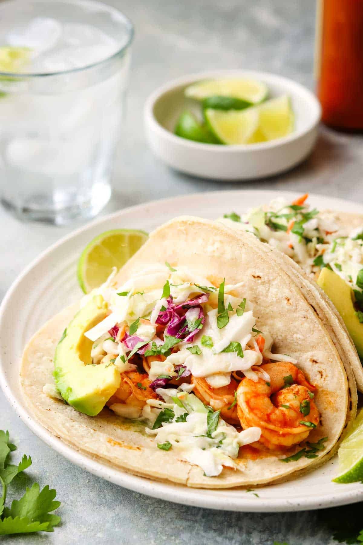 a shrimp taco on a plate with slaw.