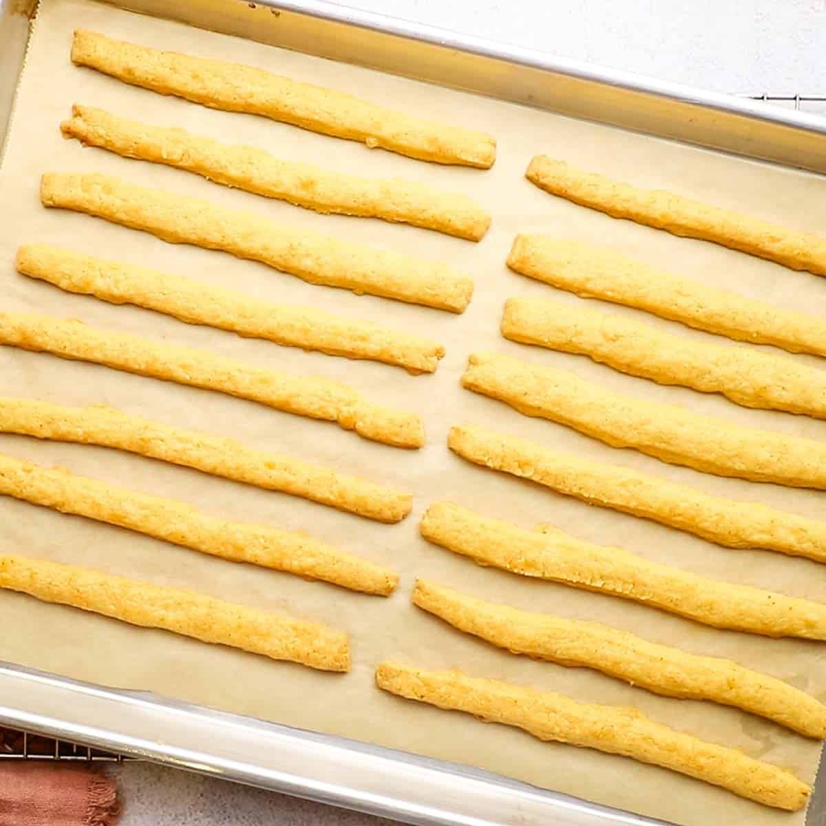 baked spicy cheese straws on a baking sheet
