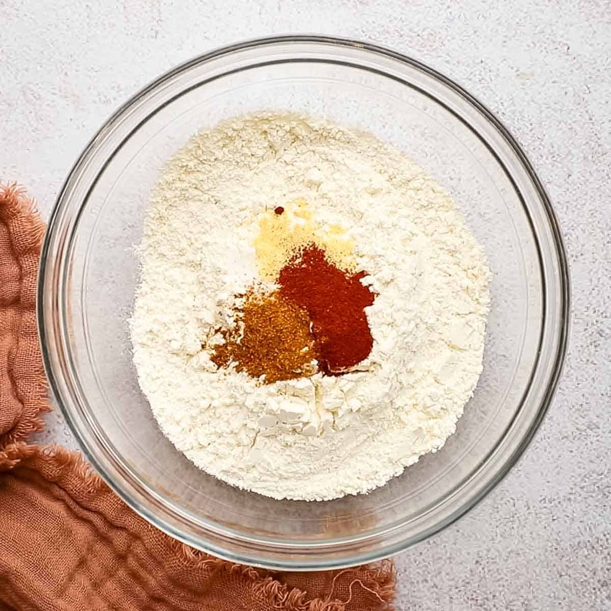 spices added to the flour in a bowl