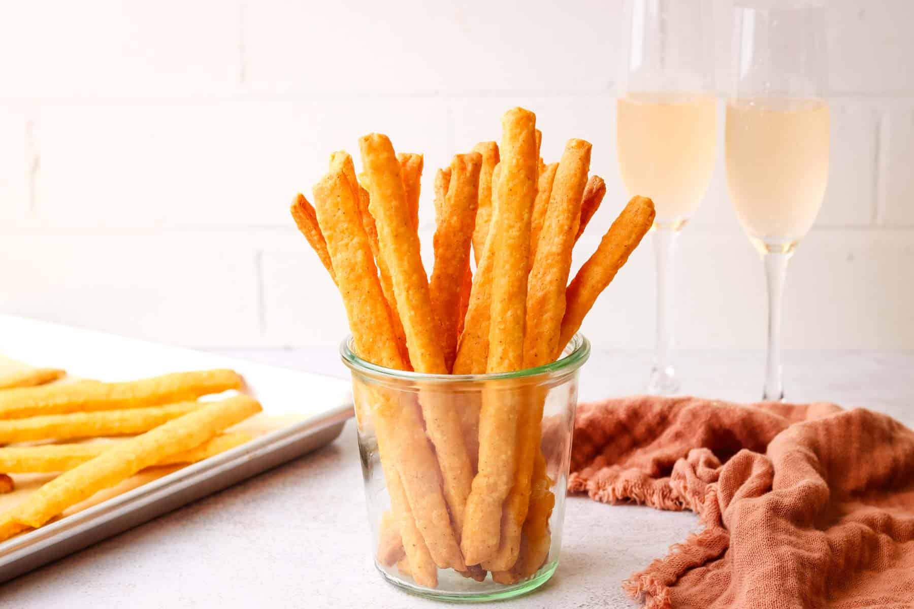 a mason jar filled with spicy cheese straws.